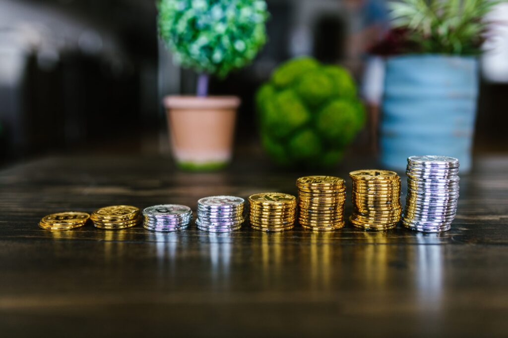 Hileras crecientes de monedas que simulan el interés compuesto y el crecimiento de fondos indexados para inversores principiantes.